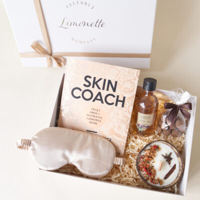 Prezent zawiera: książka Skin Coach, opaska do spania na oczy, świeca w łupinie kokosa, żel pod prysznic, orzechy pudrowane kakao.