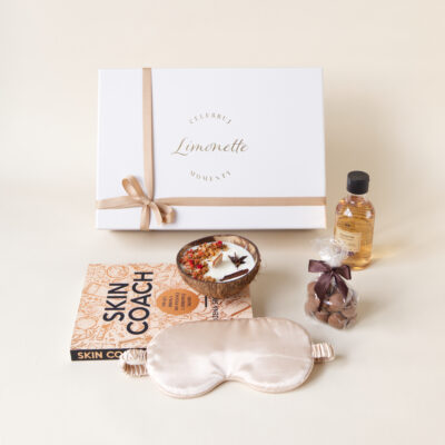 Prezent zawiera: książka Skin Coach, opaska do spania na oczy, świeca w łupinie kokosa, żel pod prysznic, orzechy pudrowane kakao.